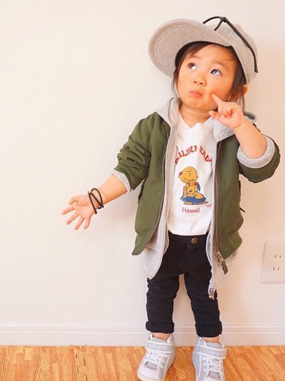 グリーン系のブルゾン、グレー系のパーカー、ブラック系のパンツを着用したキッズの冬コーディネートの1枚目の写真