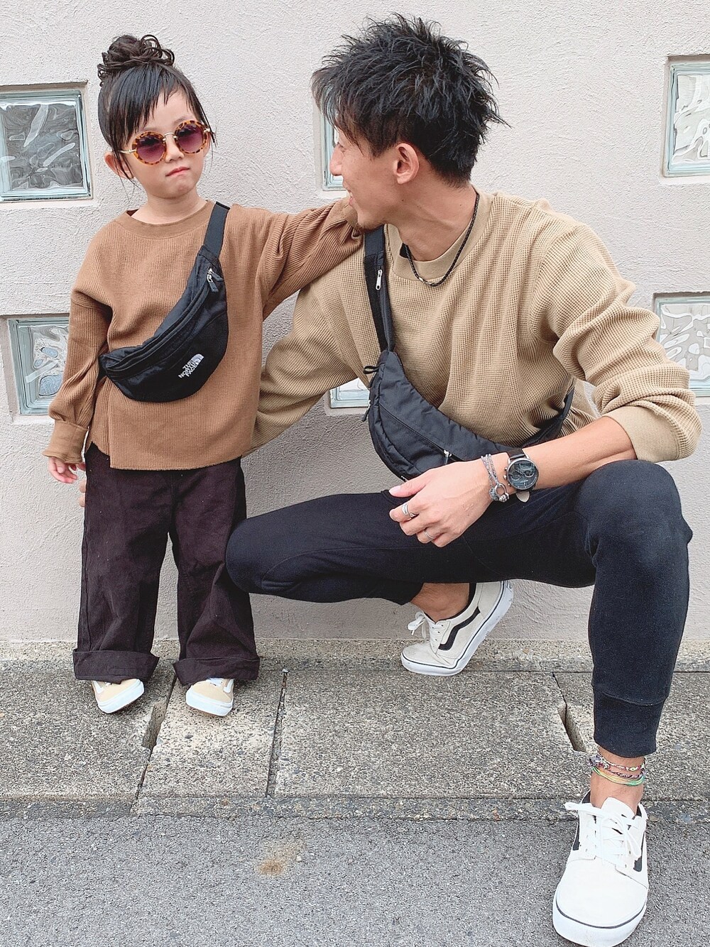 ブラック系のその他パンツ、ブラック系のボディバッグ/ウエストポーチ、ベージュ系のスニーカーを着用したキッズの秋コーディネートの1枚目の写真