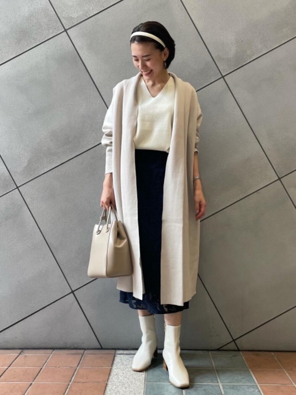 ホワイト系のブーツ、ベージュ系のカーディガン/ボレロ、ホワイト系のニット/セーターを着用したレディースの秋コーディネートの1枚目の写真