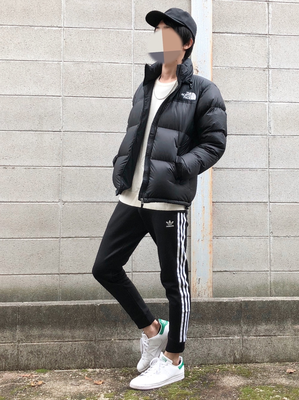 ブラック系のダウンジャケット/コート、ブラック系のスウェットパンツ、ホワイト系のスニーカーを着用したメンズの冬コーディネートの1枚目の写真