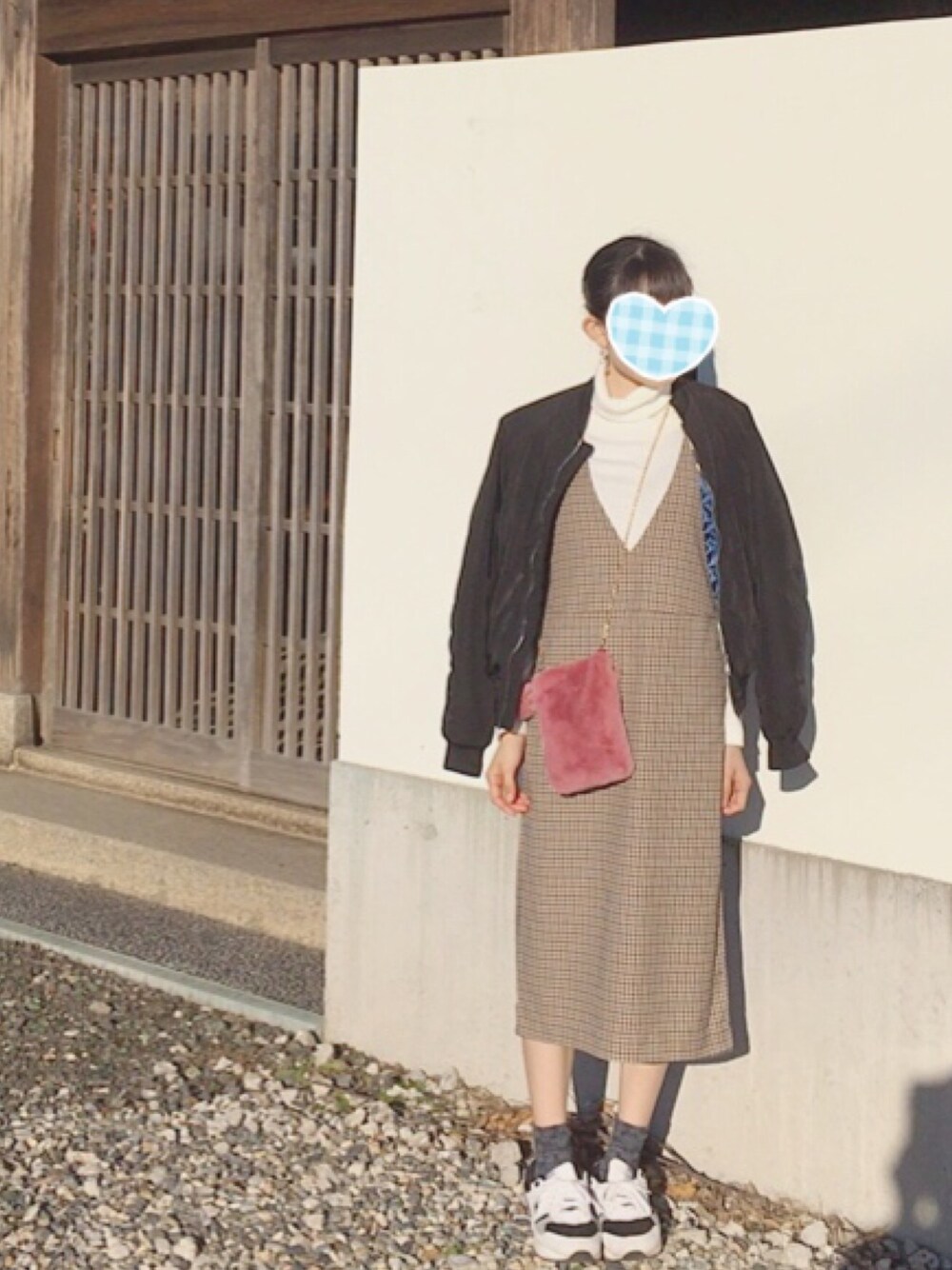 ブラック系のブルゾン、ブラウン系のワンピース、ピンク系のショルダーバッグを着用したレディースの冬コーディネートの1枚目の写真