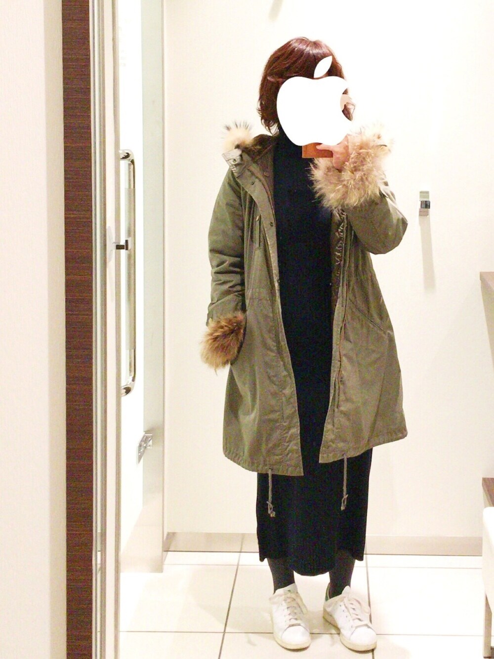 ブラウン系のモッズコート、ブルー系のワンピース、ホワイト系のスニーカーを着用したレディースの冬コーディネートの1枚目の写真