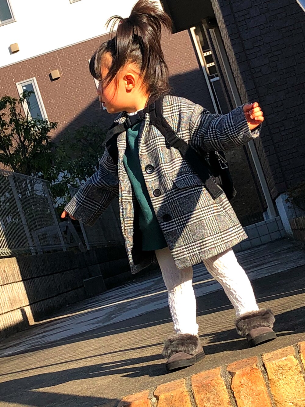 グレー系のチェスターコート、グリーン系のスウェット、グレー系のスリッポンを着用したキッズの冬コーディネートの1枚目の写真