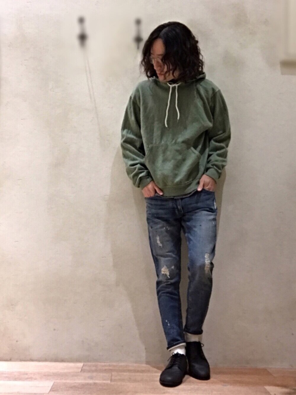 ブルー系のデニムパンツ、グリーン系のパーカーを着用したメンズの冬コーディネートの1枚目の写真