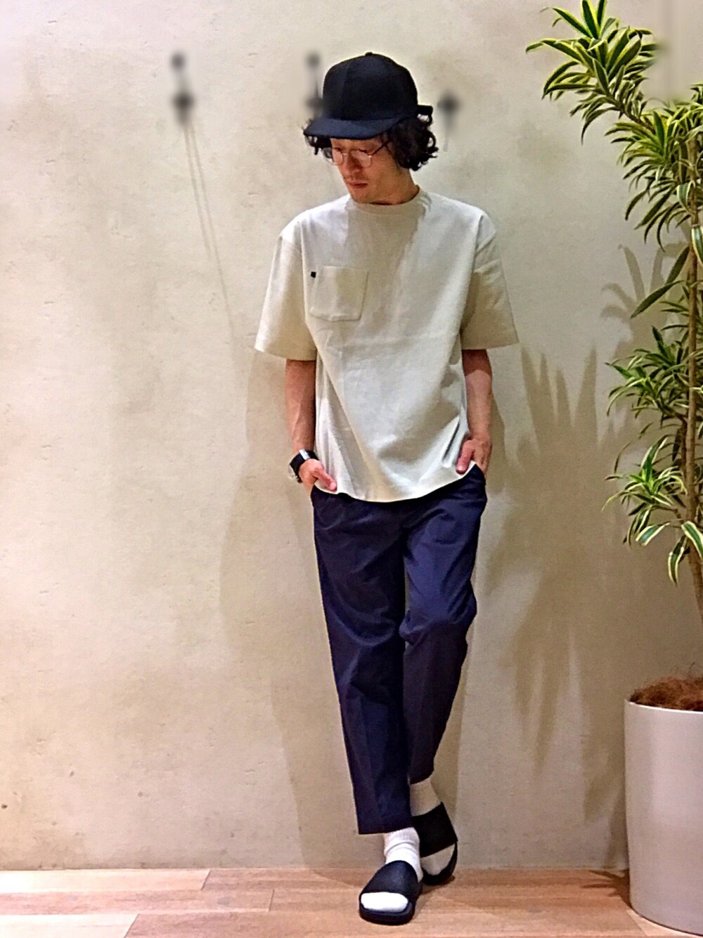 ベージュ系のTシャツ/カットソー、ブルー系のスラックス、ブラック系のサンダルを着用したメンズの春コーディネートの1枚目の写真