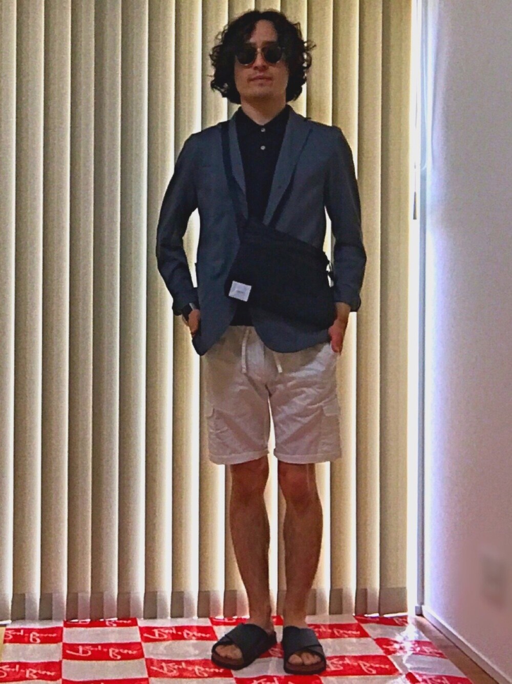 ブラック系のバッグ、グレー系のテーラードジャケット、ホワイト系のカーゴパンツを着用したメンズの夏コーディネートの1枚目の写真