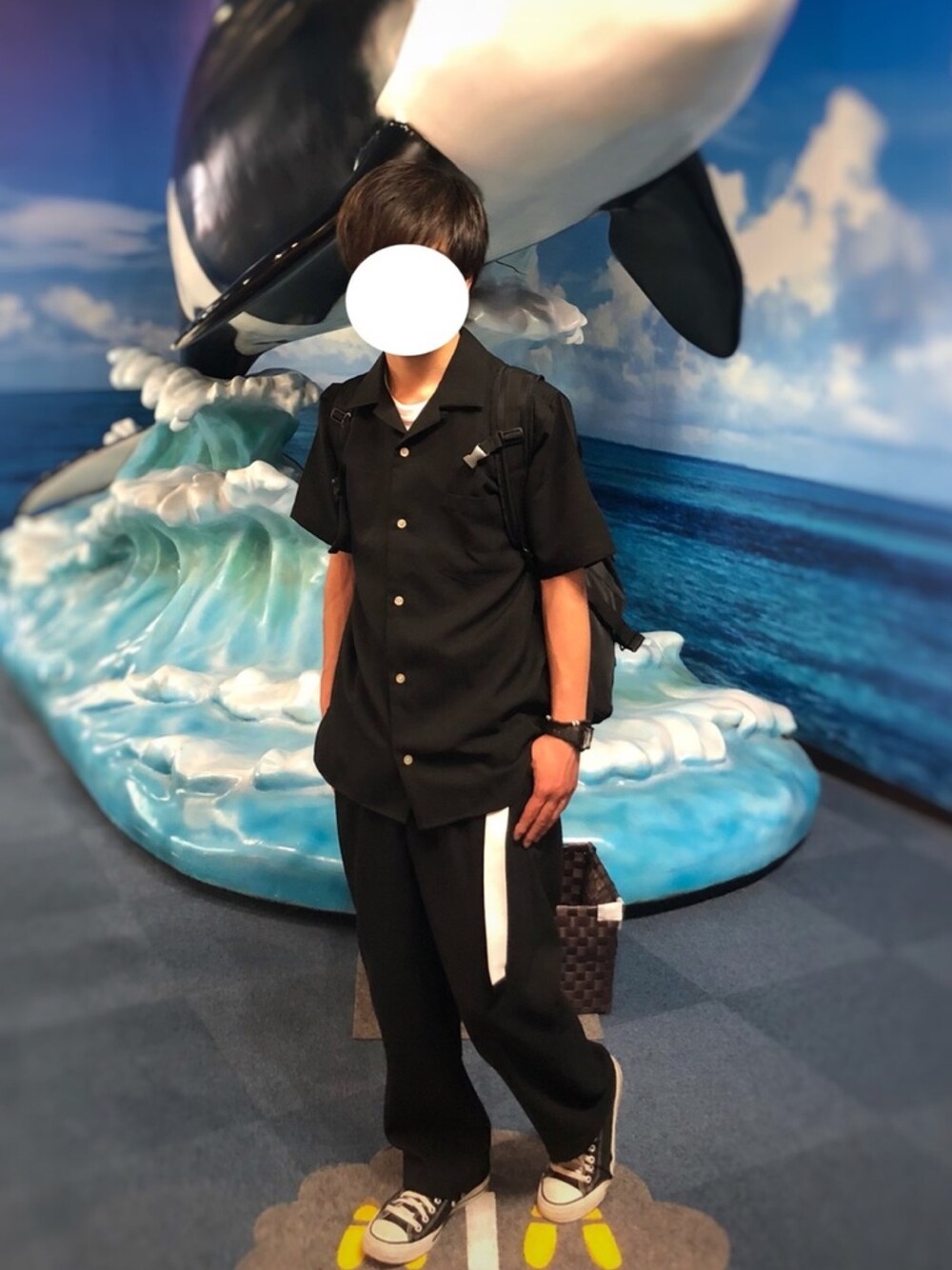 ブラック系のスニーカー、ブラック系のスラックス、ホワイト系のTシャツ/カットソーを着用したメンズの春コーディネートの1枚目の写真