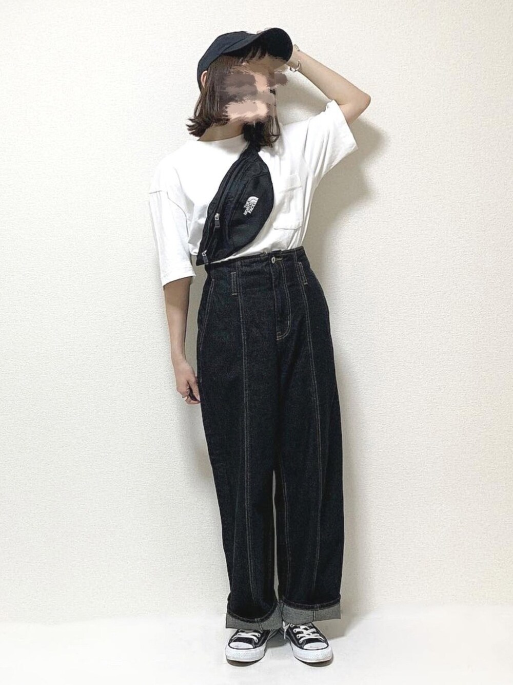 ブラック系のデニムパンツ、ブラック系のスニーカー、ブラック系のボディバッグ/ウエストポーチを着用したレディースの春コーディネートの1枚目の写真