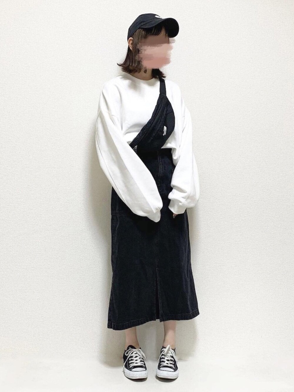 ホワイト系のスウェット、ブラック系のデニムスカート、ブラック系のボディバッグ/ウエストポーチを着用したレディースの秋コーディネートの1枚目の写真