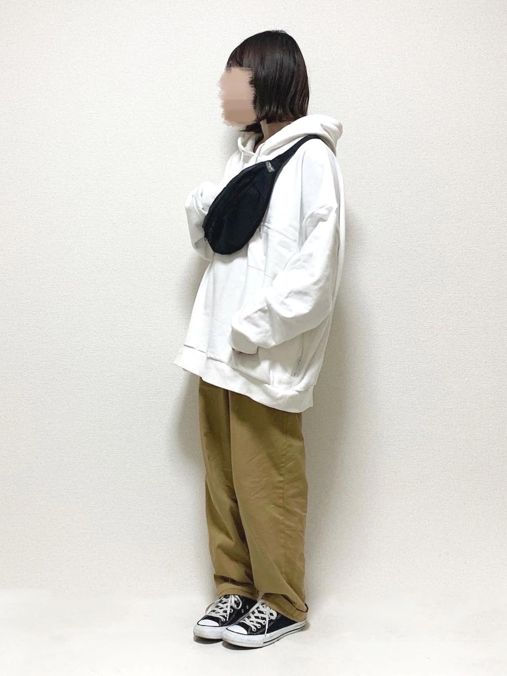 ホワイト系のパーカー、ベージュ系のその他パンツ、ブラック系のボディバッグ/ウエストポーチを着用したレディースの冬コーディネートの1枚目の写真