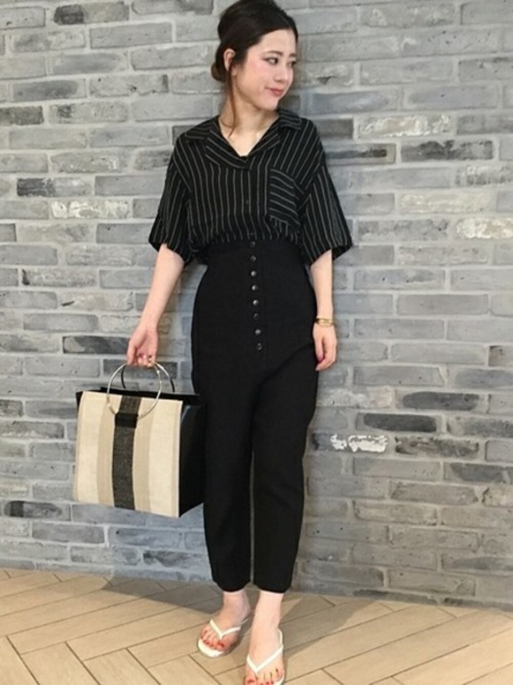 ホワイト系のビーチサンダル、ブラック系のトートバッグを着用したレディースの夏コーディネートの1枚目の写真