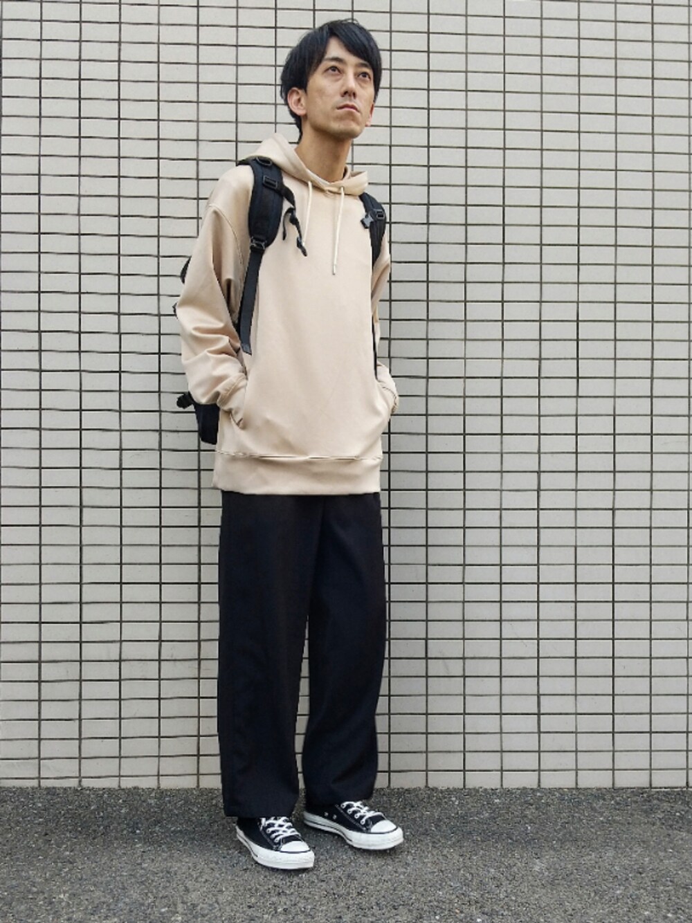 ベージュ系のスラックス、ベージュ系のパーカーを着用したメンズの春コーディネートの1枚目の写真