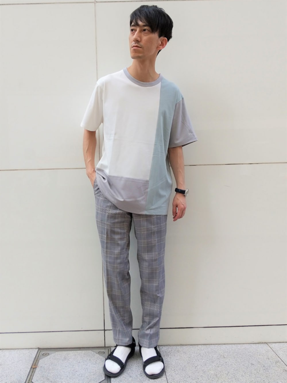 ブルー系のTシャツ/カットソー、グレー系のスラックスを着用したメンズの夏コーディネートの1枚目の写真