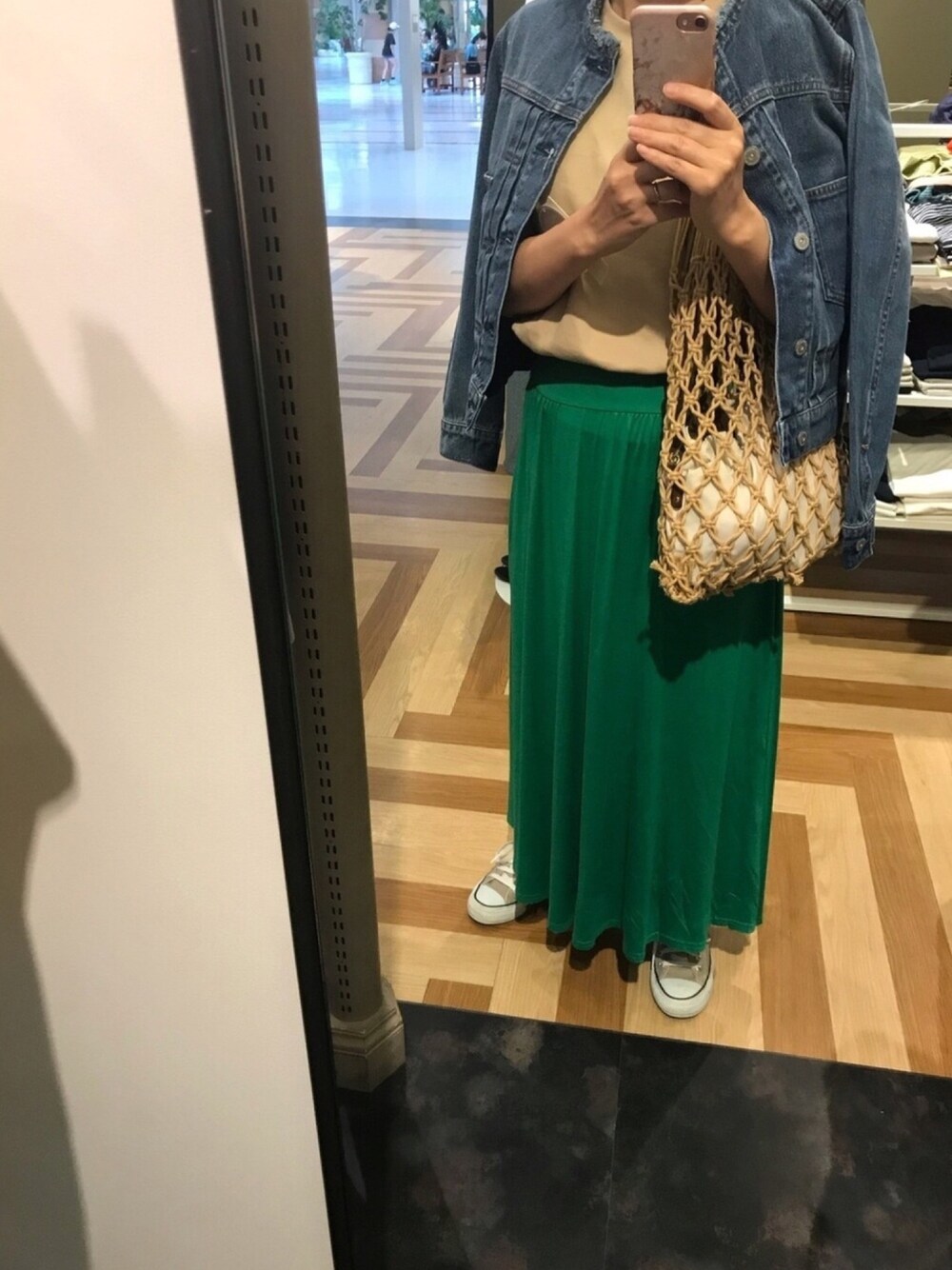 グリーン系のスカート、ベージュ系のスニーカー、ベージュ系のバッグを着用したレディースの夏コーディネートの1枚目の写真