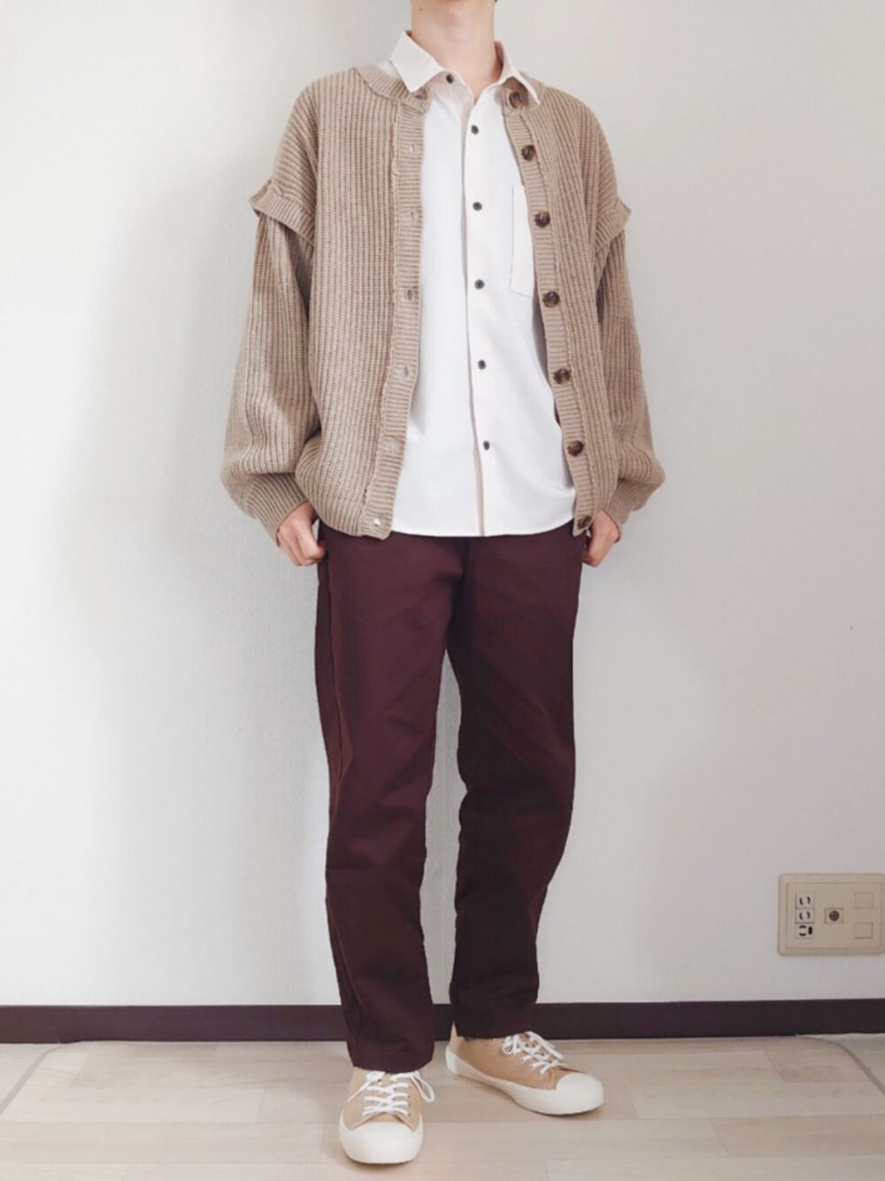 ベージュ系のカーディガン/ボレロ、ホワイト系のシャツ/ブラウス、ブラウン系のパンツを着用したメンズの春コーディネートの1枚目の写真
