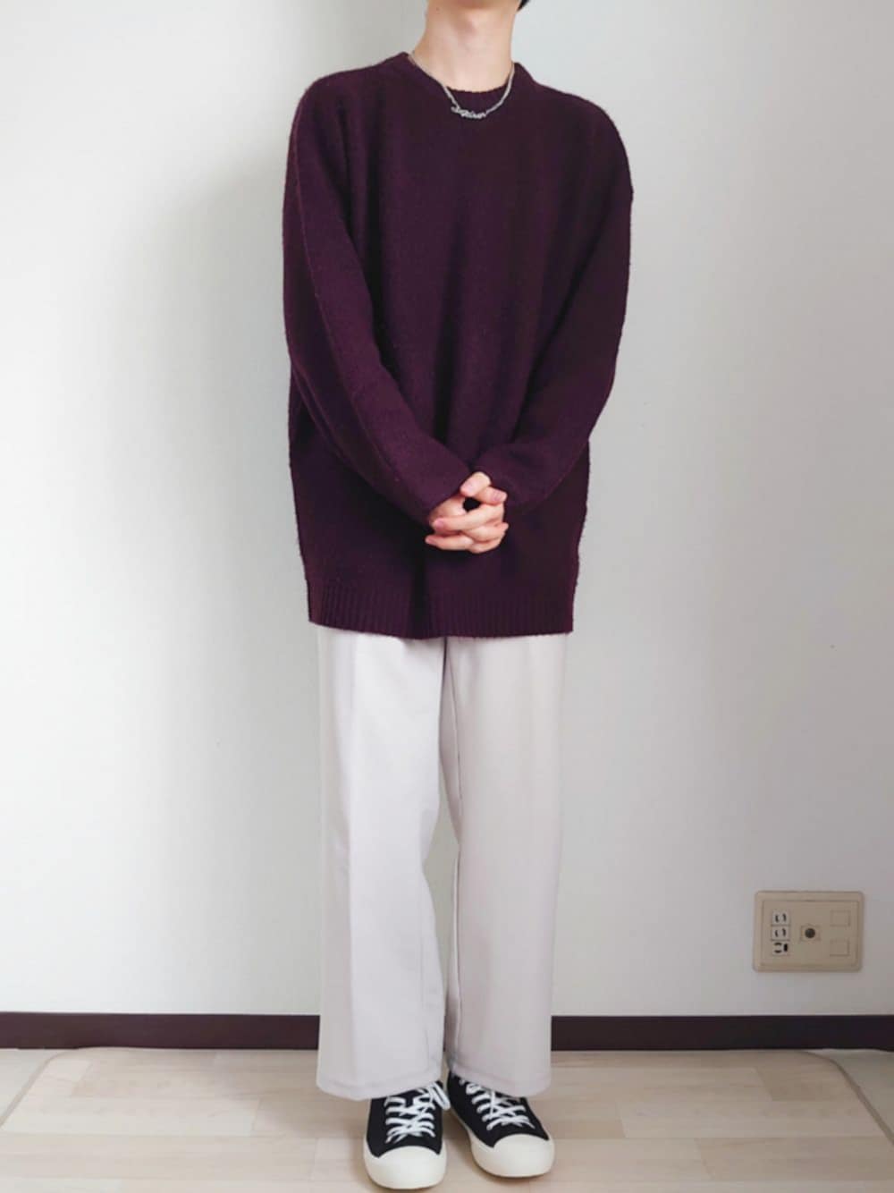 レッド系のニット/セーター、ホワイト系のパンツ、ブラック系のスニーカーを着用したメンズの春コーディネートの1枚目の写真