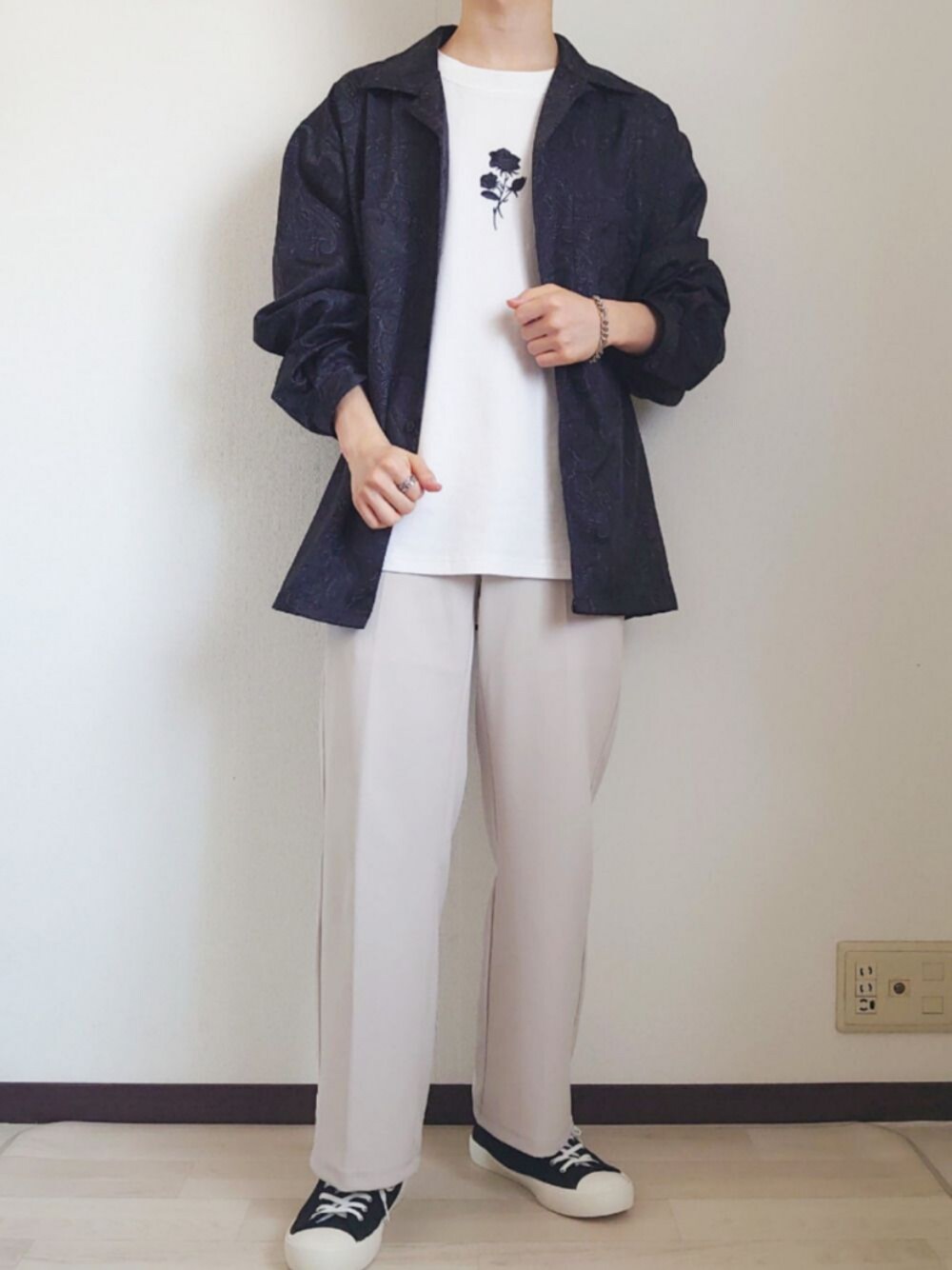 ホワイト系のパンツ、ブラック系のシャツ/ブラウス、ブラック系のスニーカーを着用したメンズの春コーディネートの1枚目の写真