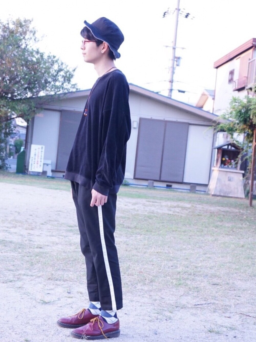 ブラック系のスウェット、ブラック系のスラックス、レッド系のブーツを着用したメンズの秋コーディネートの1枚目の写真