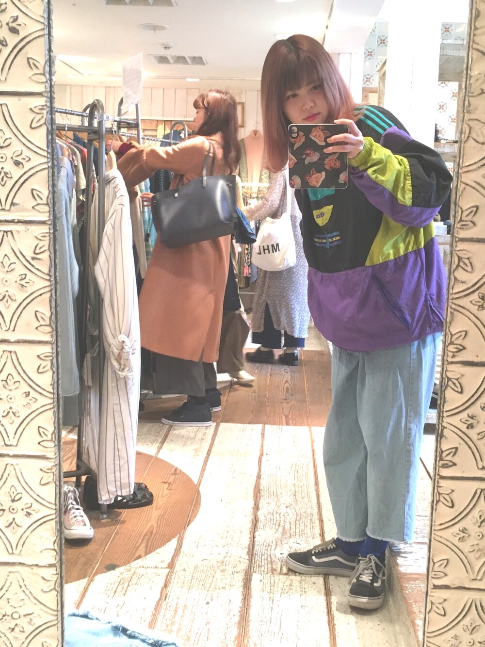 パープル系のナイロンジャケット、ブルー系のデニムパンツ、ブルー系のスニーカーを着用したレディースの春コーディネートの1枚目の写真