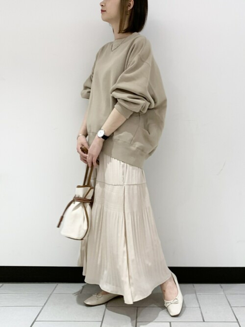ホワイト系のショルダーバッグ、ベージュ系のスウェット、ホワイト系のスカートを着用したレディースの春コーディネートの1枚目の写真