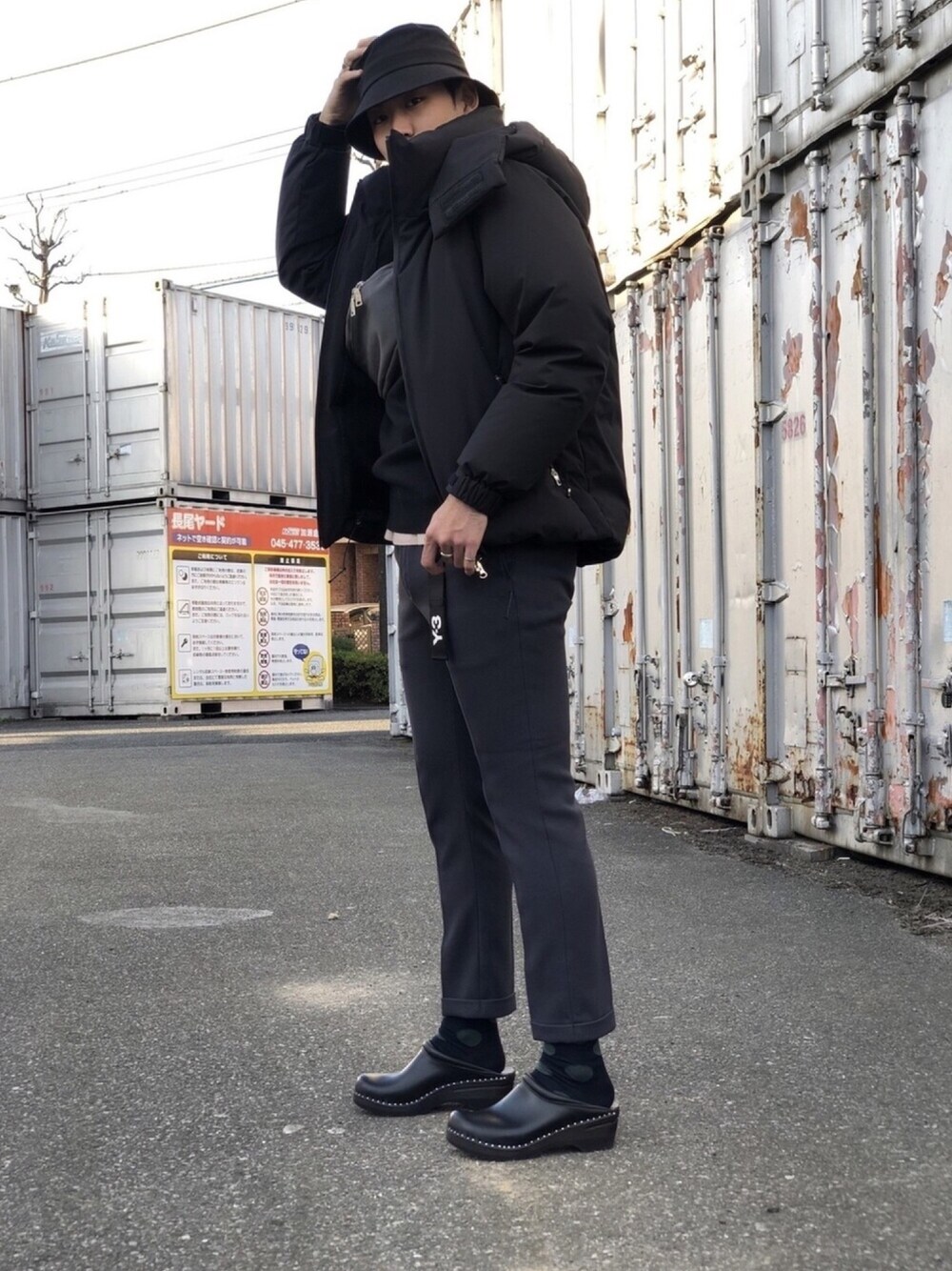 ブラック系のシューズ、ブラック系のニット/セーター、グレー系のスラックスを着用したメンズの冬コーディネートの1枚目の写真