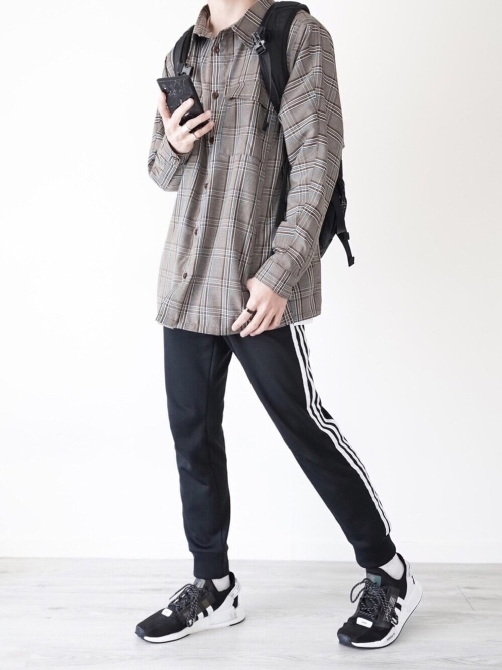 ホワイト系のTシャツ/カットソー、ブラック系のスウェットパンツ、ブラック系のスニーカーを着用したメンズの春コーディネートの1枚目の写真