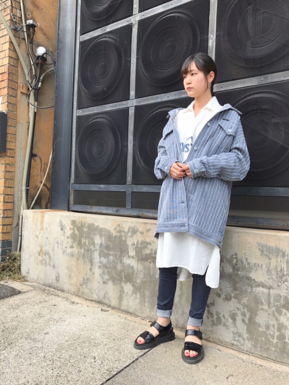 ブルー系のデニムジャケット、ホワイト系のシャツ/ブラウス、ブラック系のサンダルを着用したレディースの春コーディネートの1枚目の写真