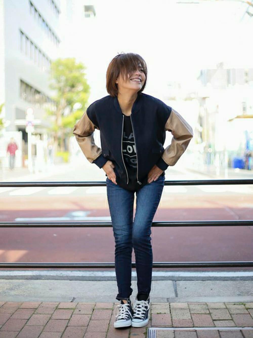 ブルー系のスタジャン、ブラック系のスウェット、ブルー系のデニムパンツを着用したレディースの冬コーディネートの1枚目の写真