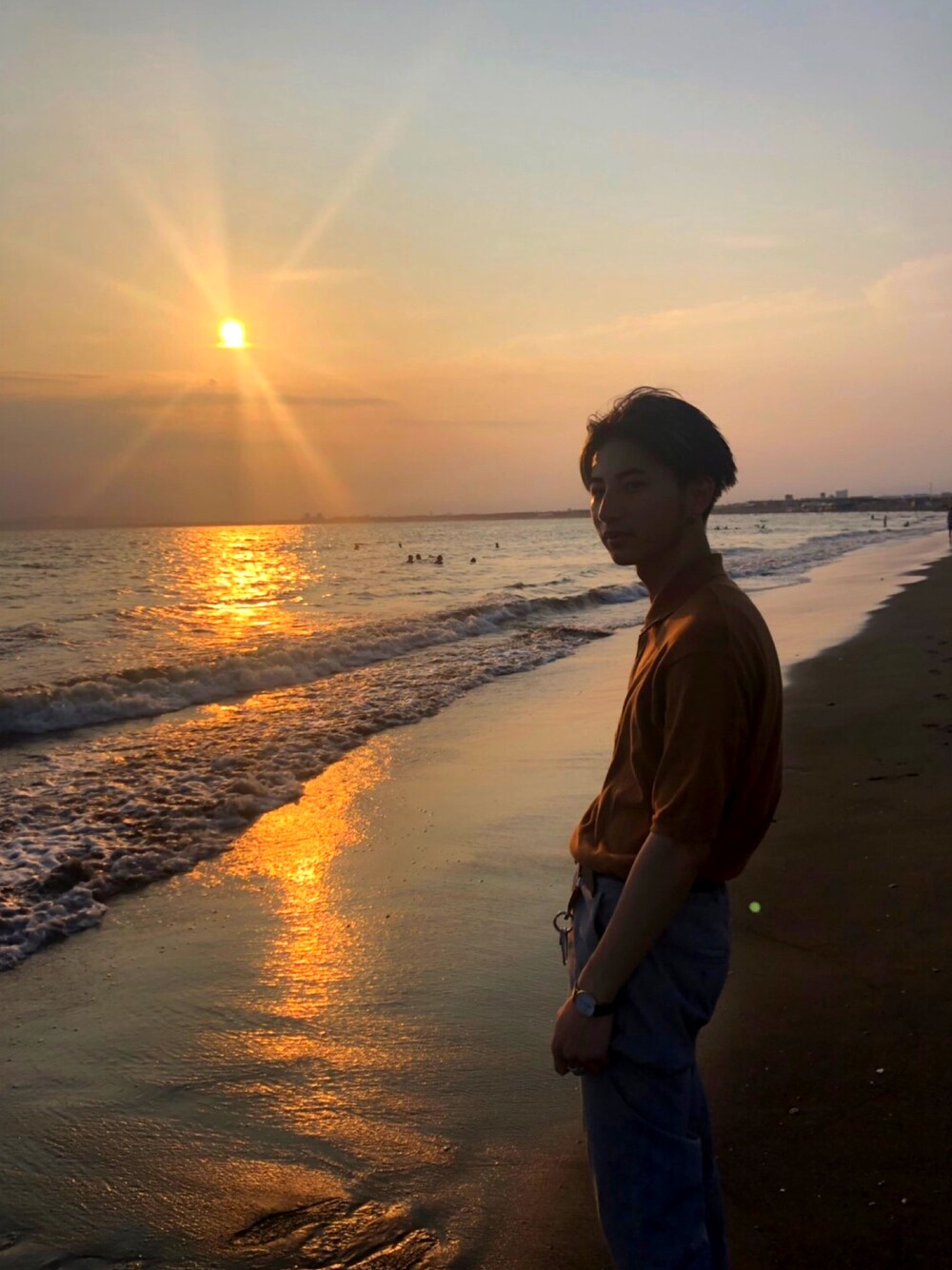 ブラウン系のポロシャツ、グレー系のスラックス、ブラウン系のスニーカーを着用したメンズの夏コーディネートの1枚目の写真