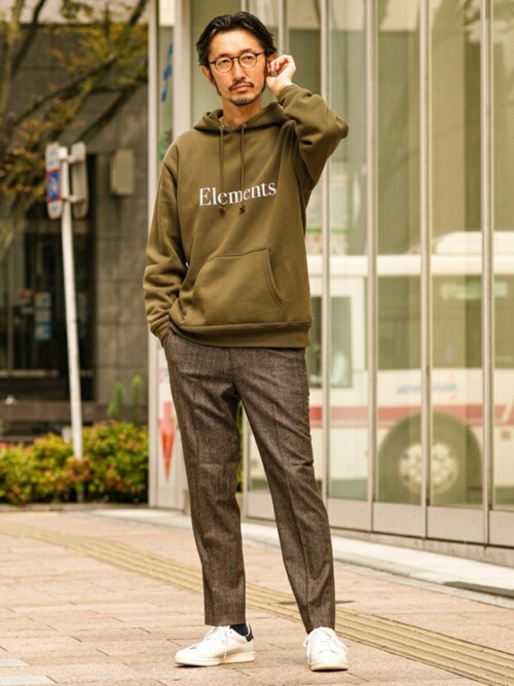 グリーン系のパーカー、ブラウン系のその他パンツ、ブルー系のスニーカーを着用したメンズの秋コーディネートの1枚目の写真