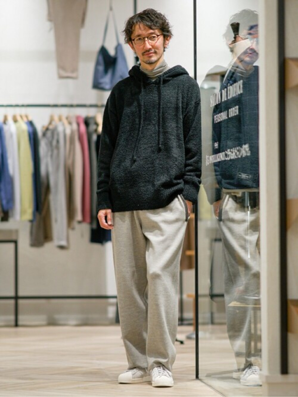 ブラック系のパーカー、ホワイト系のニット/セーター、ベージュ系のその他パンツを着用したメンズの冬コーディネートの1枚目の写真