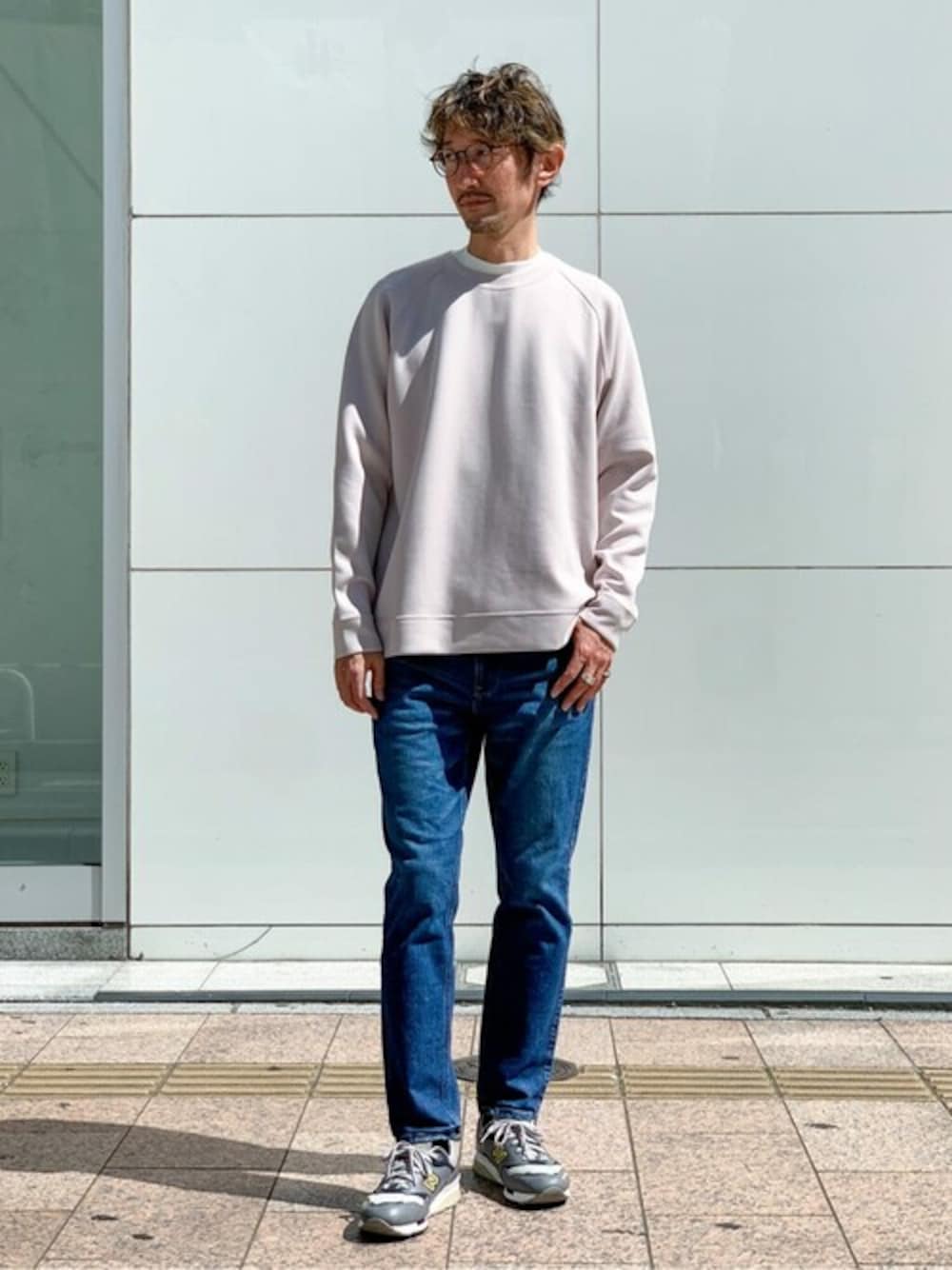 ピンク系のスウェット、ホワイト系のTシャツ/カットソー、ブルー系のデニムパンツを着用したメンズの秋コーディネートの1枚目の写真