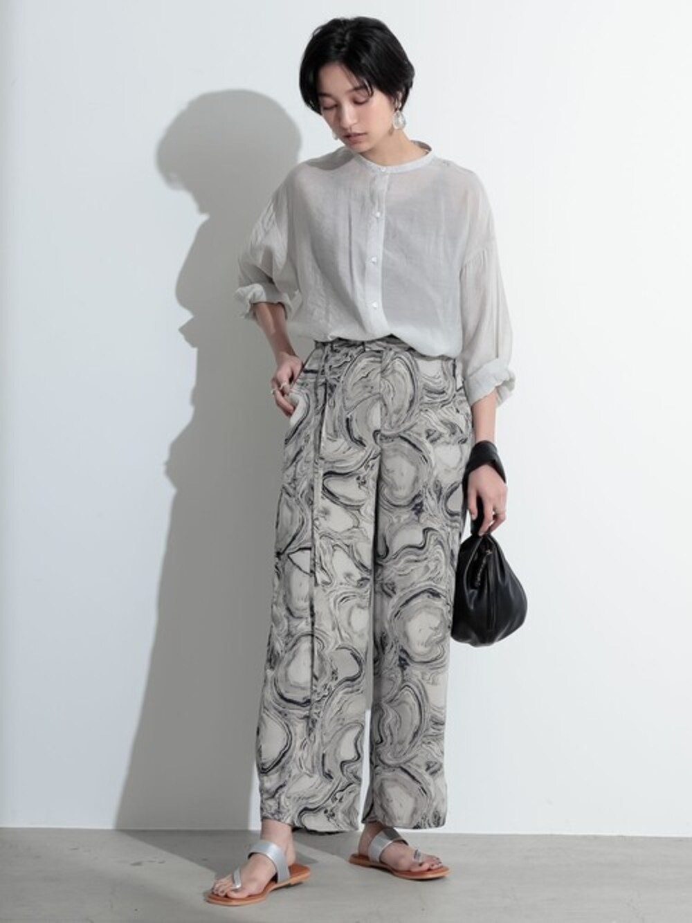 ホワイト系のシャツ/ブラウス、グレー系のその他パンツを着用したレディースの春コーディネートの1枚目の写真