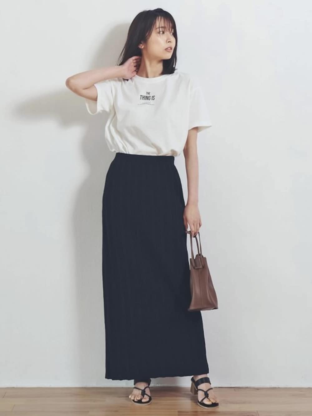 ホワイト系のTシャツ/カットソー、ブラック系のサンダル、ブラック系のスカートを着用したレディースの春コーディネートの1枚目の写真