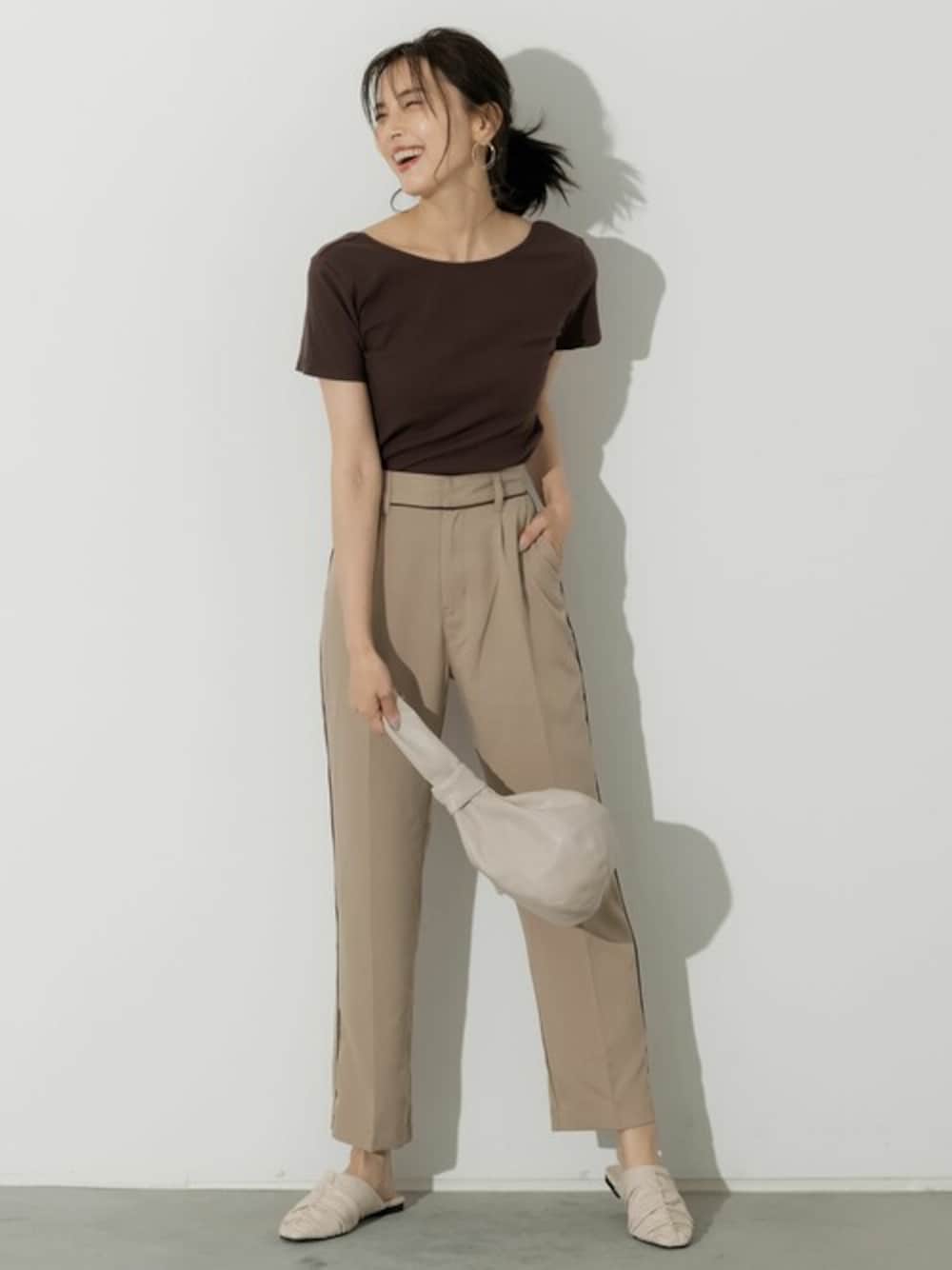 ベージュ系のスラックス、ホワイト系のパンプスを着用したレディースの夏コーディネートの1枚目の写真