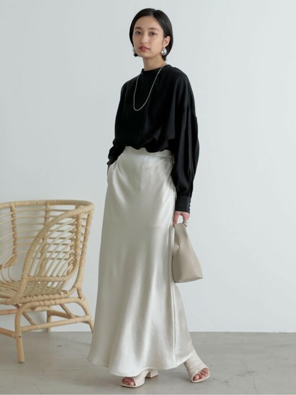 ブラック系のシャツ/ブラウス、ホワイト系のスカート、ホワイト系のサンダルを着用したレディースの冬コーディネートの1枚目の写真