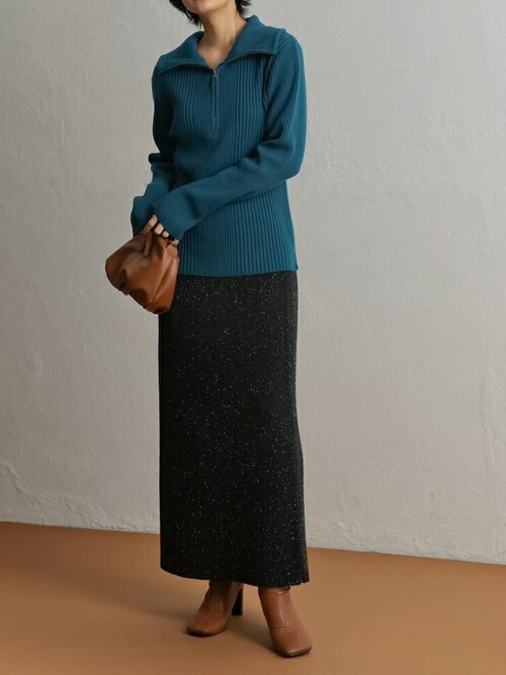 ブルー系のニット/セーター、ブラック系のスカート、イエロー系のショルダーバッグを着用したレディースの冬コーディネートの1枚目の写真