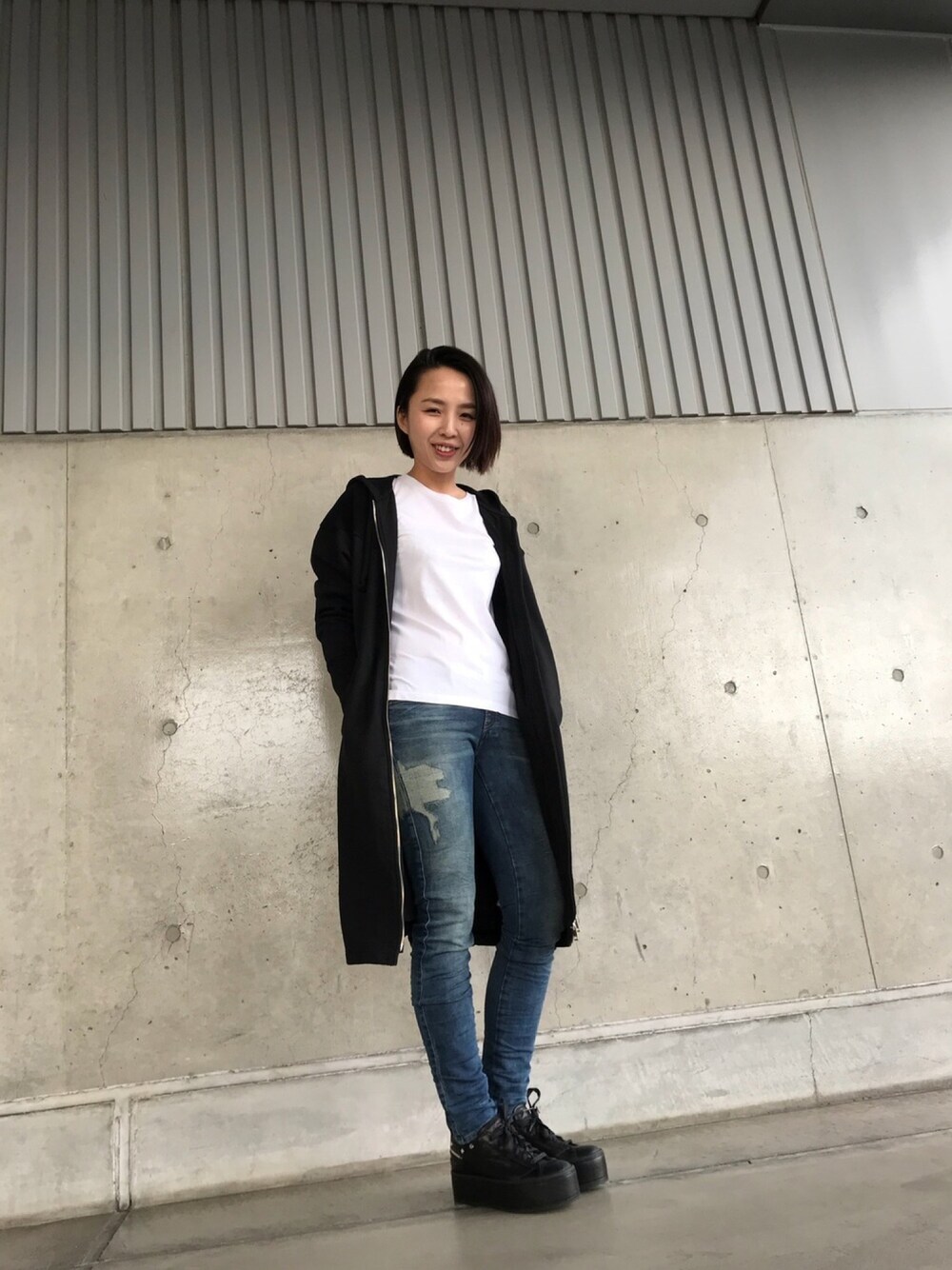 ブラック系のその他アウター、ホワイト系のTシャツ/カットソー、ブルー系のデニムパンツを着用したレディースの冬コーディネートの1枚目の写真