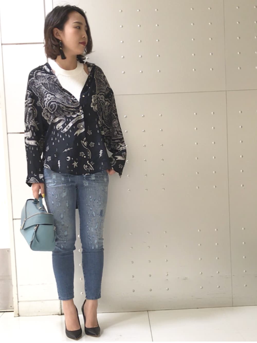 ブラック系のシャツ/ブラウス、ホワイト系のニット/セーター、ブルー系のデニムパンツを着用したレディースの春コーディネートの1枚目の写真