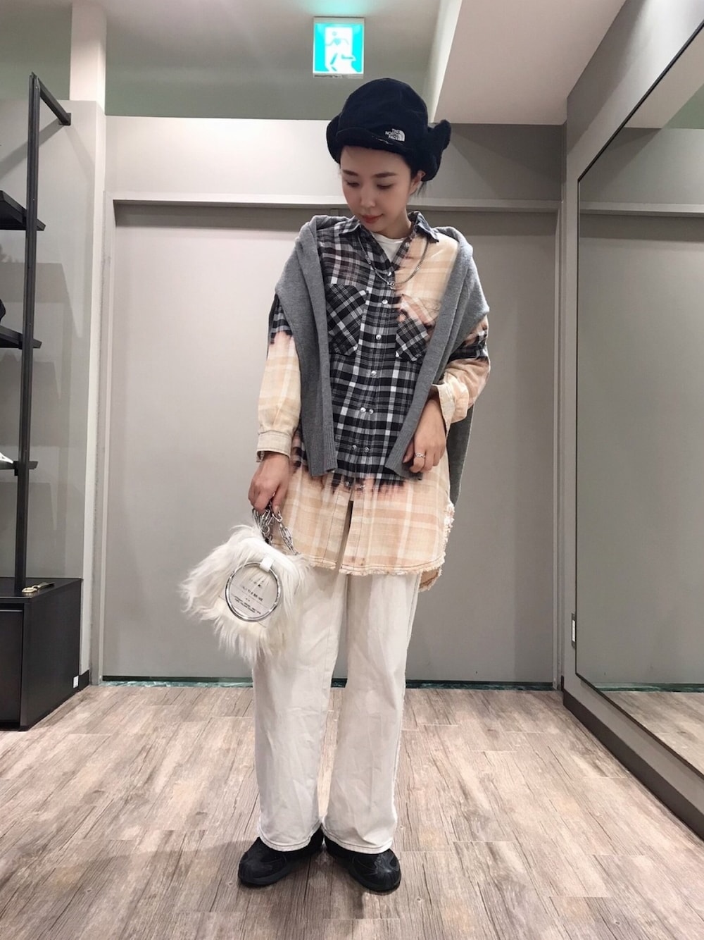 ブラック系のワンピース、ホワイト系のデニムパンツ、ブラック系のスニーカーを着用したレディースの秋コーディネートの1枚目の写真