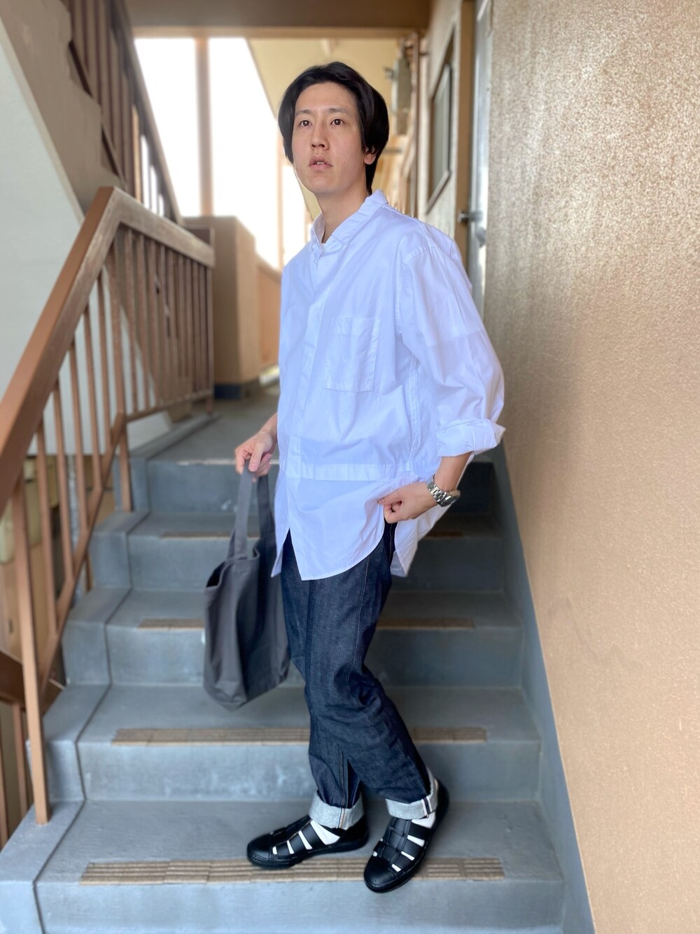 ホワイト系のシャツ/ブラウス、ブルー系のデニムパンツ、グレー系のトートバッグを着用したメンズの春コーディネートの1枚目の写真