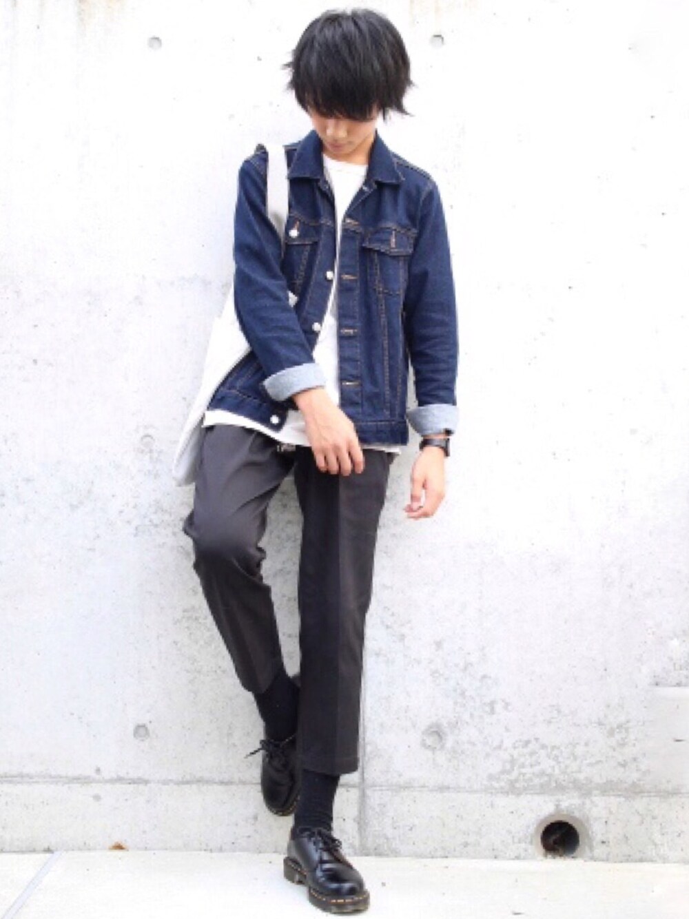 ブルー系のデニムジャケット、ベージュ系のTシャツ/カットソー、ホワイト系のトートバッグを着用したメンズの秋コーディネートの1枚目の写真