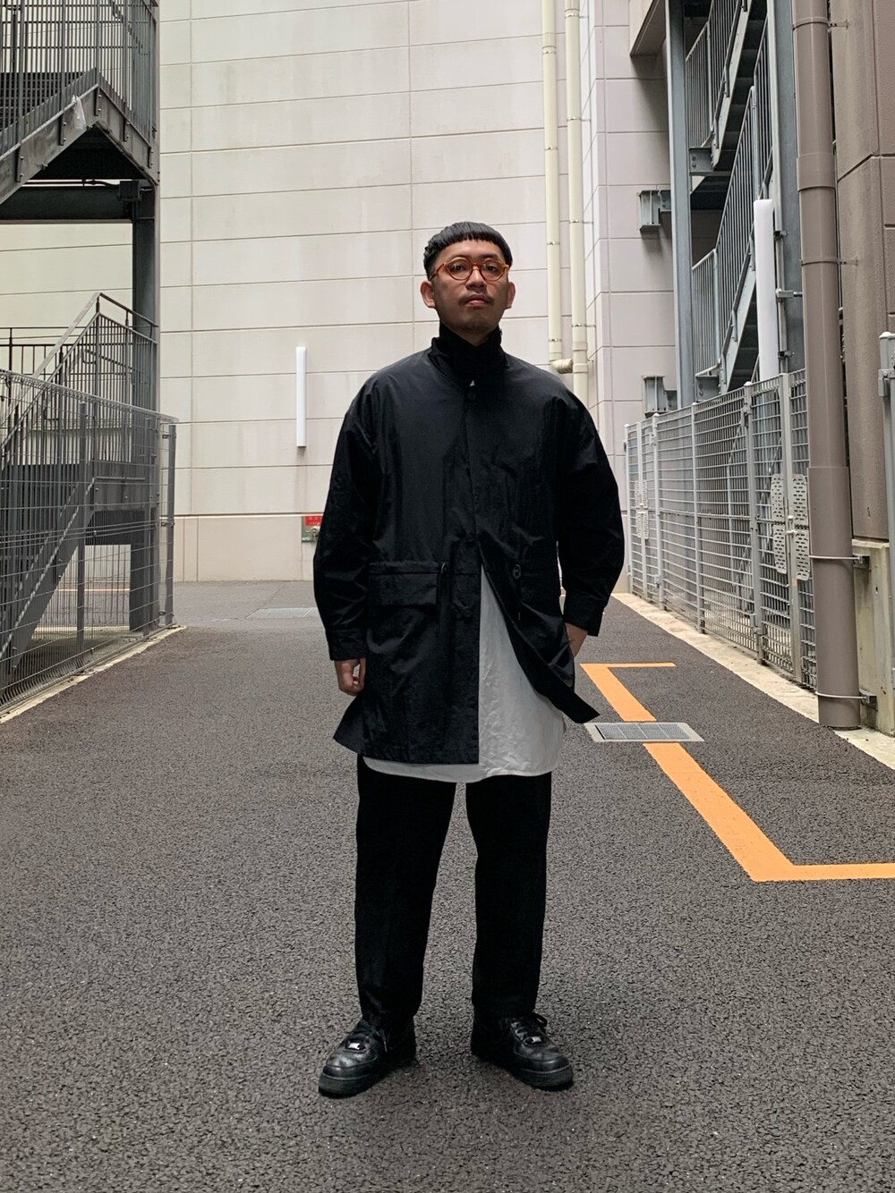 グレー系のステンカラーコート、ブラック系のその他パンツを着用したメンズの春コーディネートの1枚目の写真