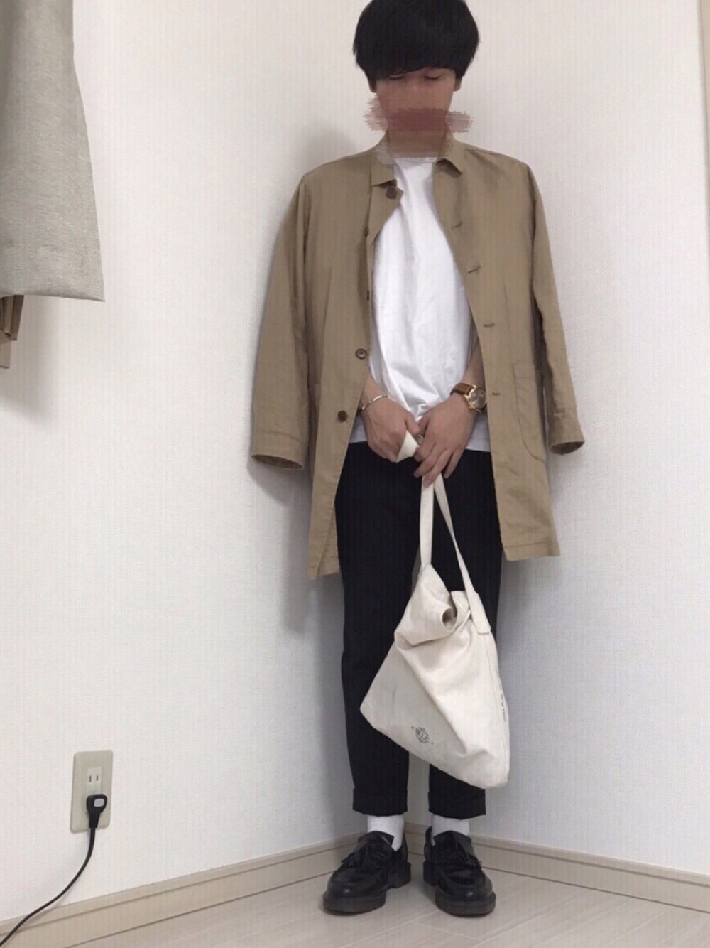ベージュ系のステンカラーコート、ブラック系のスラックス、ブラック系のドレスシューズを着用したメンズの夏コーディネートの1枚目の写真