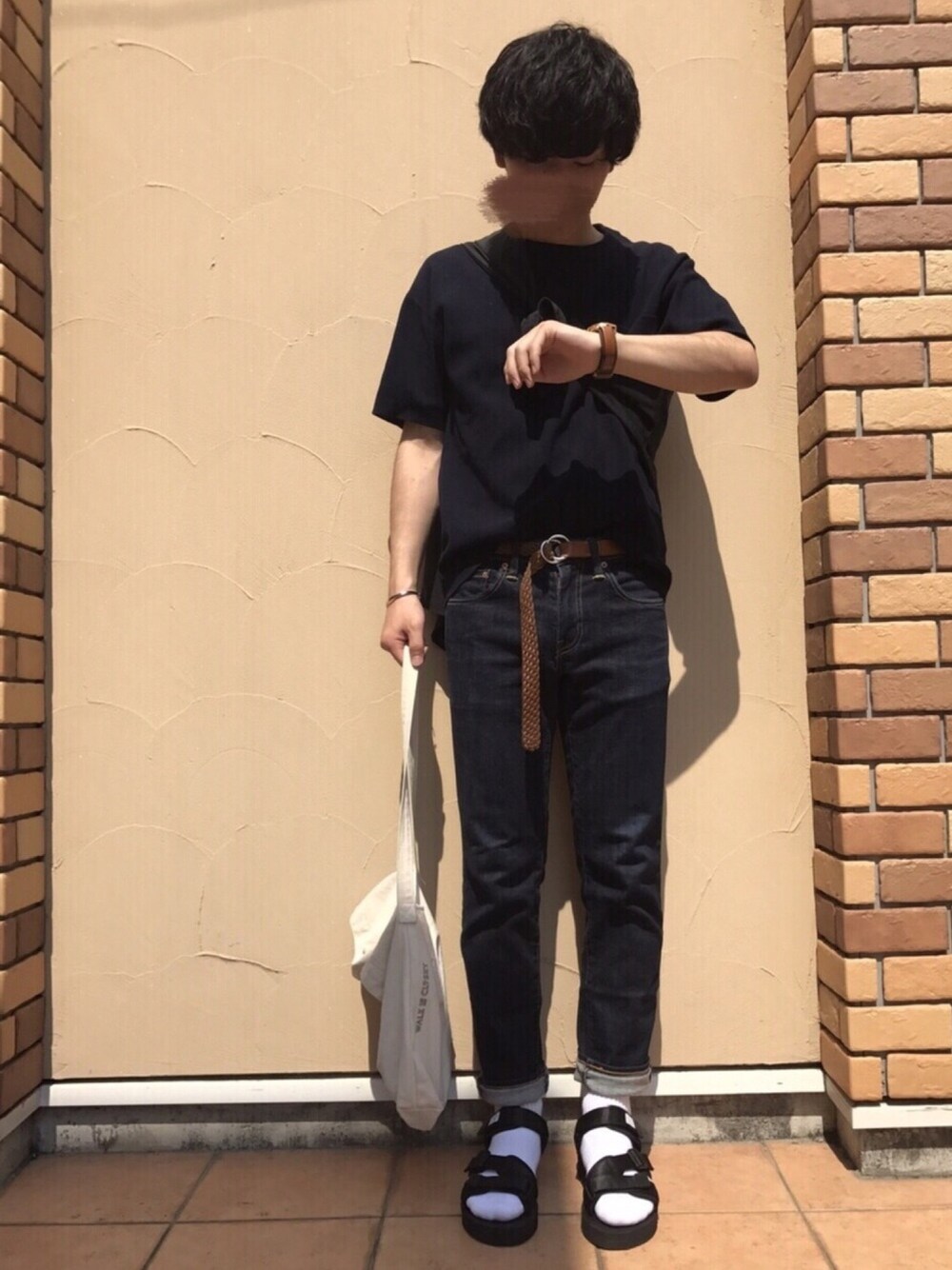 ブルー系のデニムパンツ、パープル系のTシャツ/カットソー、ブラック系のサンダルを着用したメンズの夏コーディネートの1枚目の写真