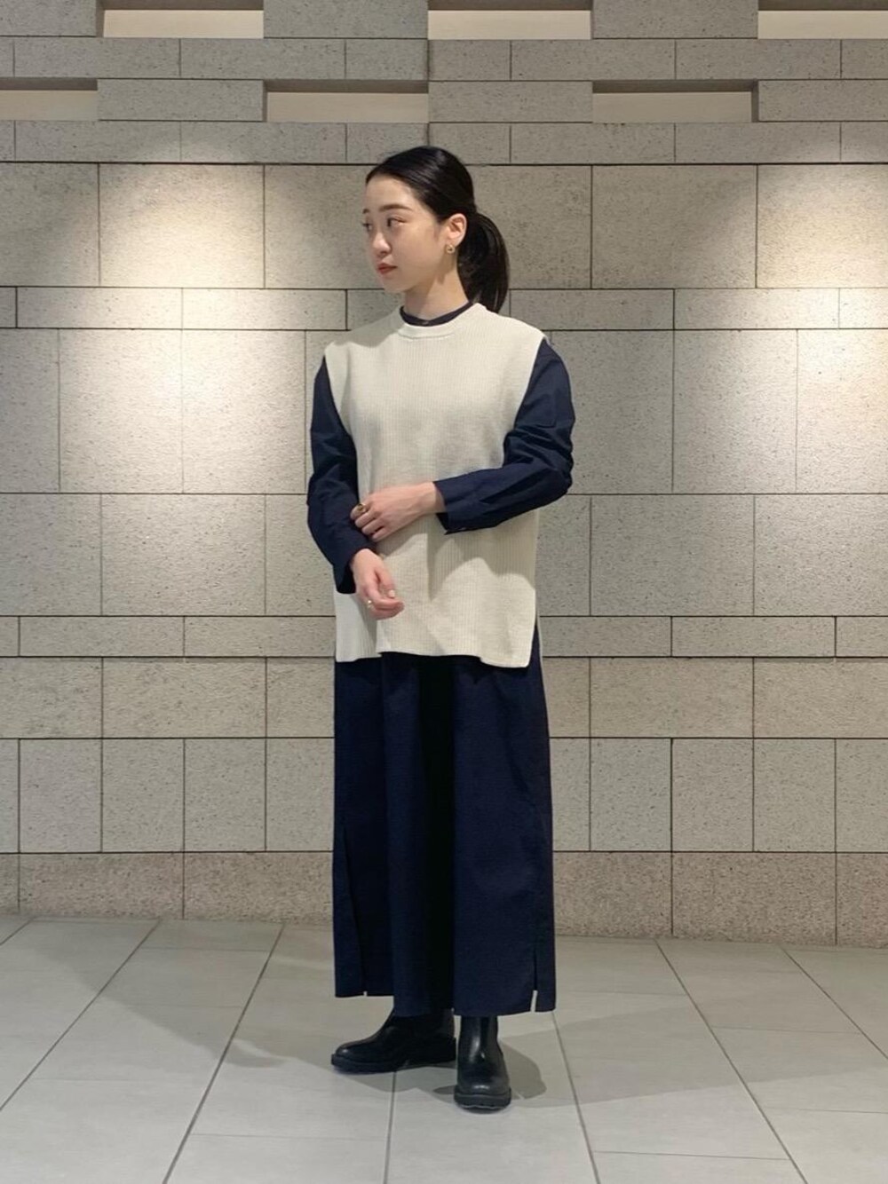 ホワイト系のベスト、ブラック系のブーツ、ブルー系のワンピースを着用したレディースの夏コーディネートの1枚目の写真