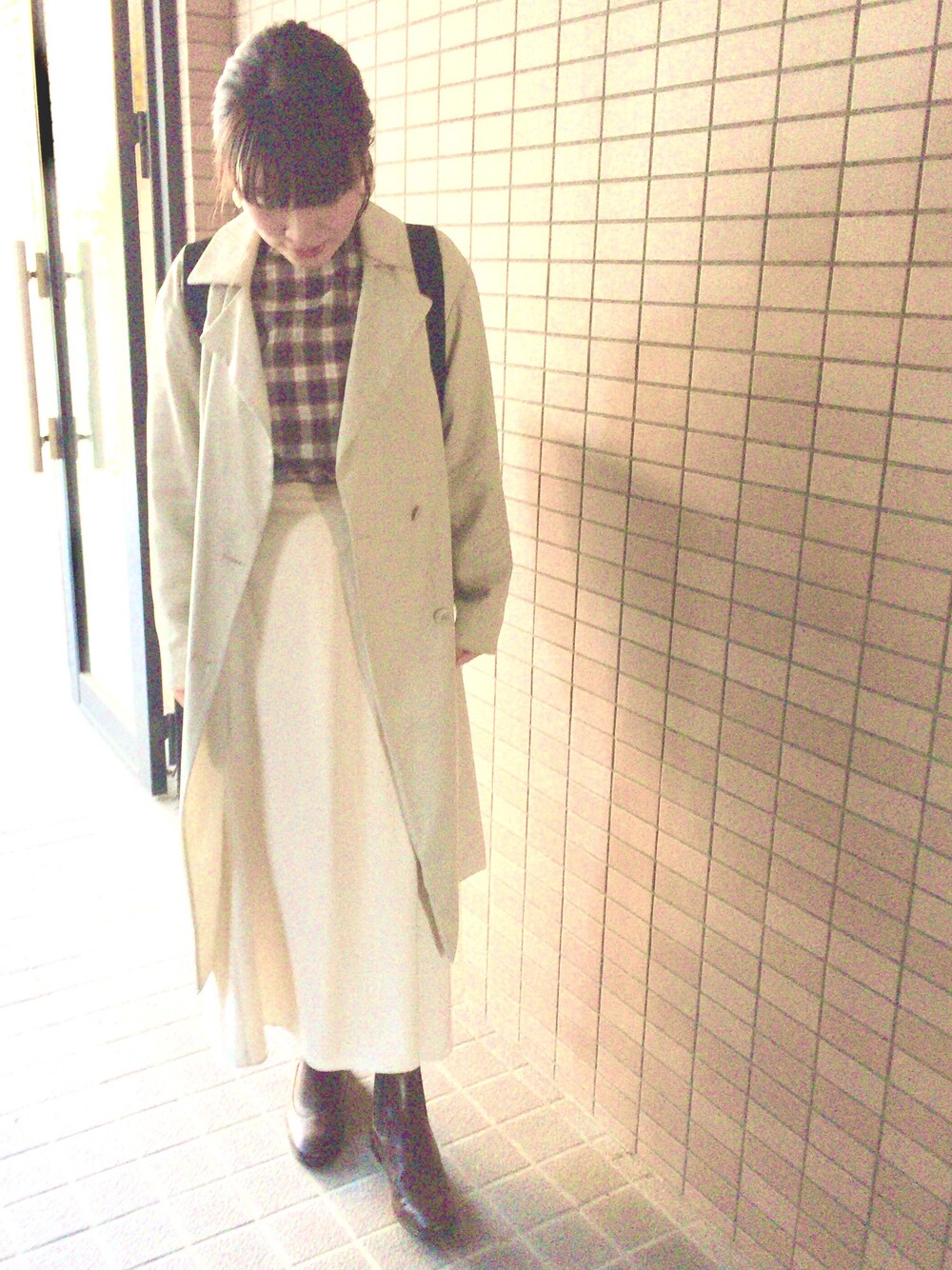 ブラック系のシャツ/ブラウス、ホワイト系のスカート、ホワイト系のトレンチコートを着用したレディースの秋コーディネートの1枚目の写真