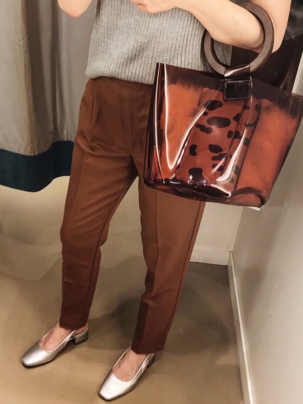 ブラウン系のハンドバッグ、イエロー系のその他パンツ、グレー系のニット/セーターを着用したレディースの秋コーディネートの1枚目の写真