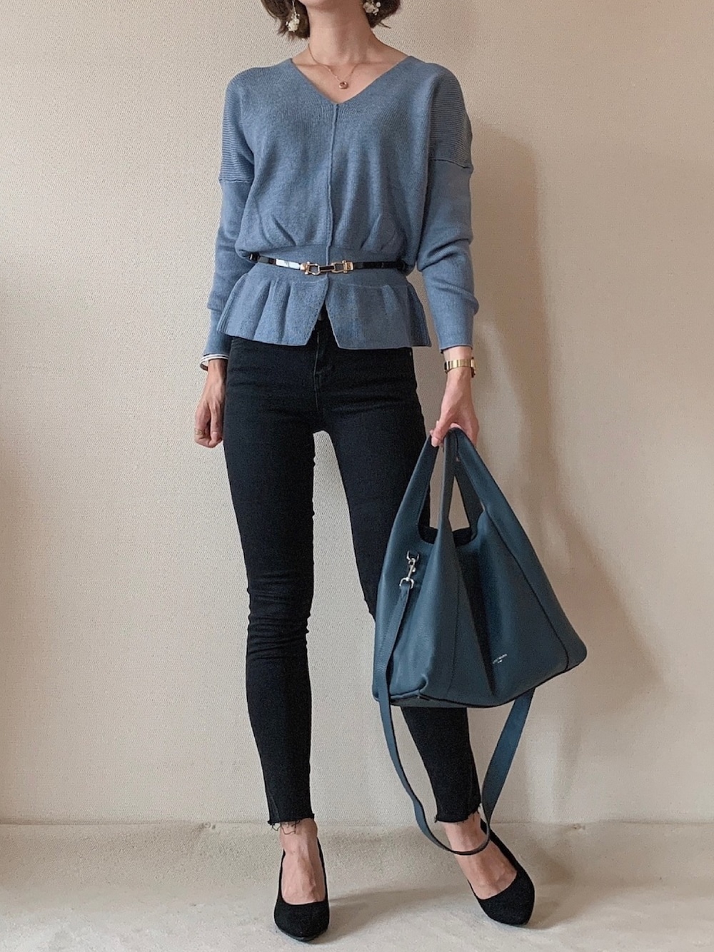 ブルー系のデニムパンツ、ブルー系のハンドバッグ、ブルー系のニット/セーターを着用したレディースの秋コーディネートの1枚目の写真