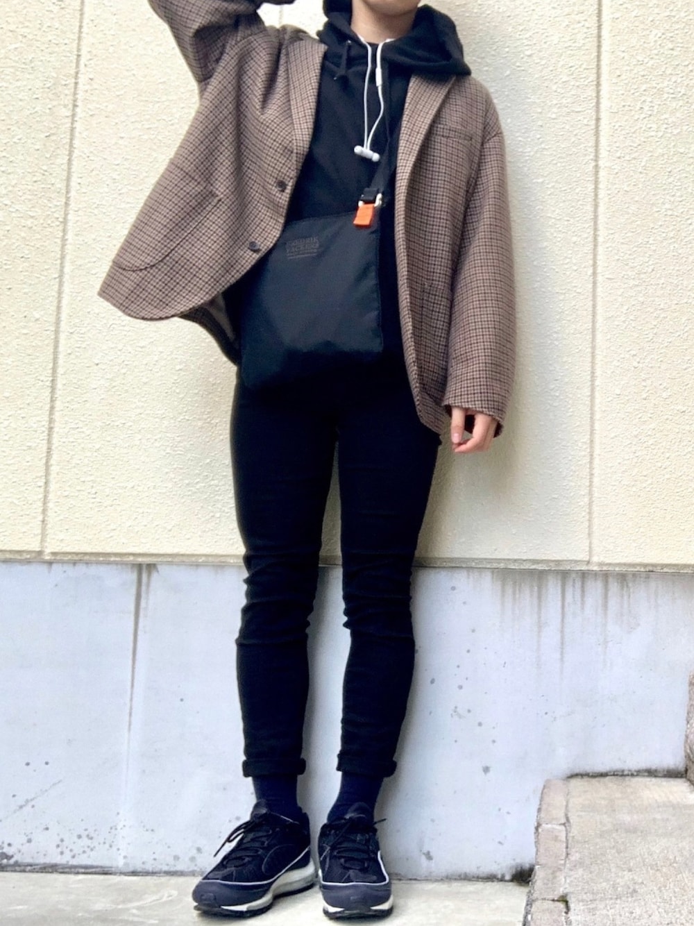 ブラック系のデニムパンツ、ブラック系のスニーカー、ブラック系のパーカーを着用したメンズの冬コーディネートの1枚目の写真